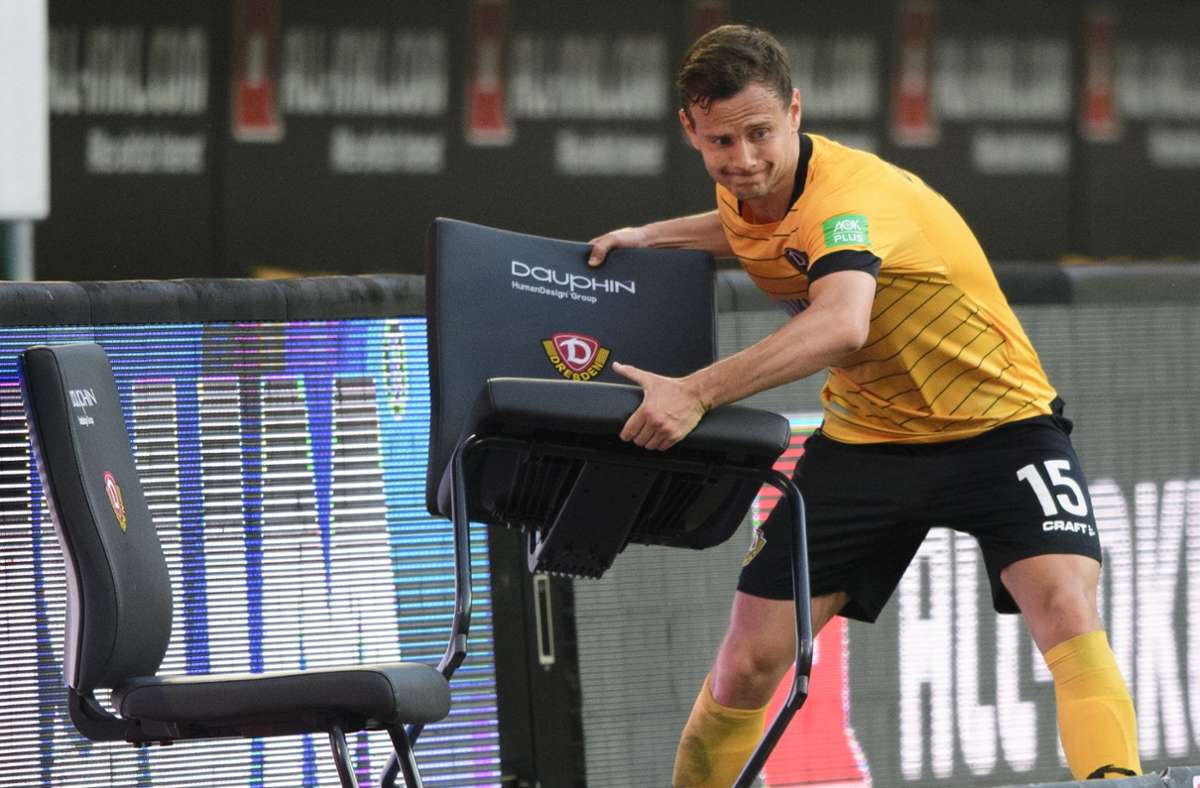 Dynamos Chris Löwe wirft nach der Niederlage gegen den HSV einen Stuhl weg. Foto: dpa/Robert Michael