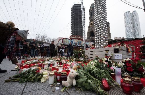 Trauernde legen am Anschlagsort auf dem Weihnachtsmarkt am Breitscheidplatz in Berlin Blumen nieder und zünden Kerzen an. Foto: dpa