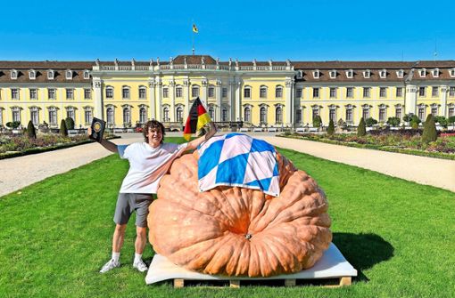 Luca Stöckl  präsentiert  seinen 1052 Kilogramm schweren Kürbis. Foto: Blühendes Barock