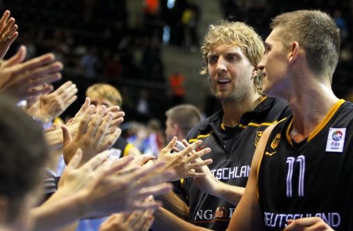Tibor Pleis (rechts) und Dirk Nowitzki feiern mit ihren Fans den Sieg über Lettlands Basketball-Auswahl. Foto: dpa