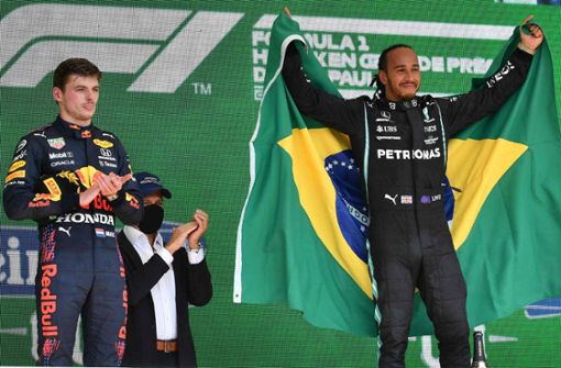 Lewis Hamilton ist selig und feiert seinen Sieg in Brasilien, Max Verstappen (li.) applaudiert emotionslos, aber artig. Foto: AFP/NELSON ALMEIDA