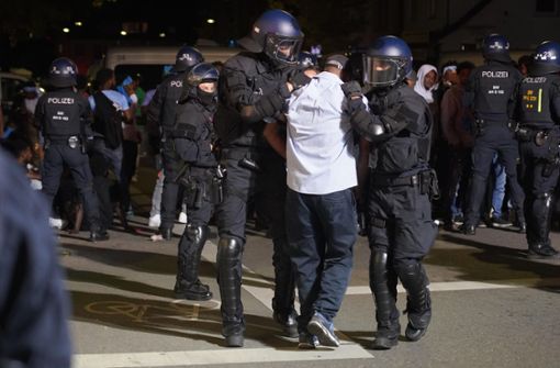 Die Polizei führt am späten Samstagabend einen Tatverdächtigen ab. Foto: Andreas Rosar