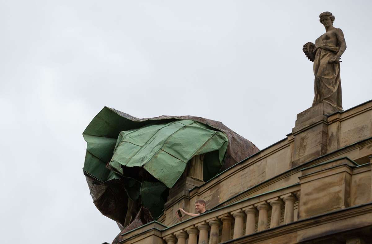 Ein Teil des abgerissenen Kupferdachs bedeckt die Statue der Architektur. Unbeschädigt blieb die Nachbarstatue, die die  Technik verkörpert.
