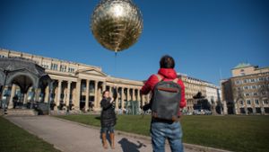 Die Künstlerin Marie Lienhard lässt ihren goldenen Ballon auf dem Schlossplatz steigen. Foto: Lichtgut/Max Kovalenko