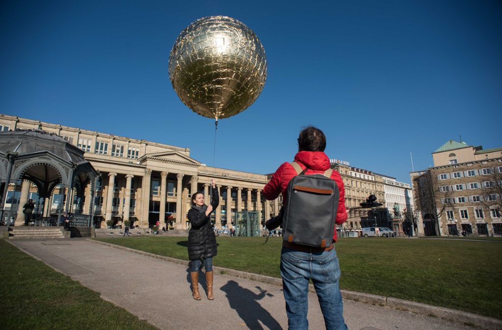 Die Künstlerin Marie Lienhard lässt ihren goldenen Ballon auf dem Schlossplatz steigen.