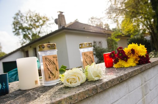 Kerzen und Blumen liegen vor dem Haus in Wedel, in dem sich ein unfassbares Familiendrama abgespielt hat. Foto: dpa