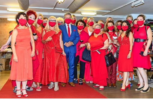 20 Personen aus 20 Haushalte dürfen sich jetzt wieder treffen: Der Red Ladys Club  Stuttgart hat die rote Maske in der Stuttgarter Factory aufgesetzt. Der einzige Mann ist OB-Kandidat Frank Nopper, die anderen Kandidaten sollen folgen. Foto: Andreas Engelhard