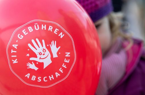Ein Kind hält während der Übergabe von 10 000 Unterschriften für ein Volksbegehren für kostenlose Kinderbetreuung an das Innenministerium von Baden-Württemberg einen Luftballon mit der Aufschrift „Kitagebühren abschaffen“ in der Hand. Foto: dpa
