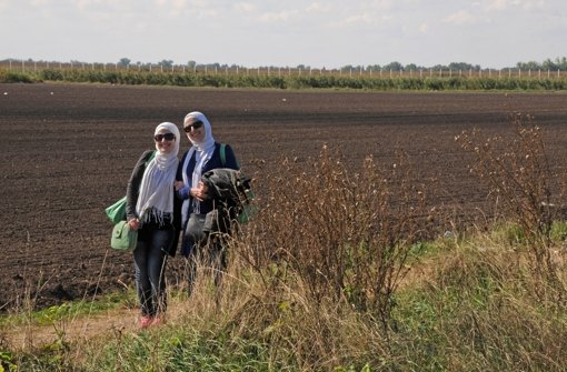 Zwei junge Frauen aus Syrien posieren für die Kamera. Sie sind auf dem Weg von Ungarn zur serbischen Grenze. Foto: dpa
