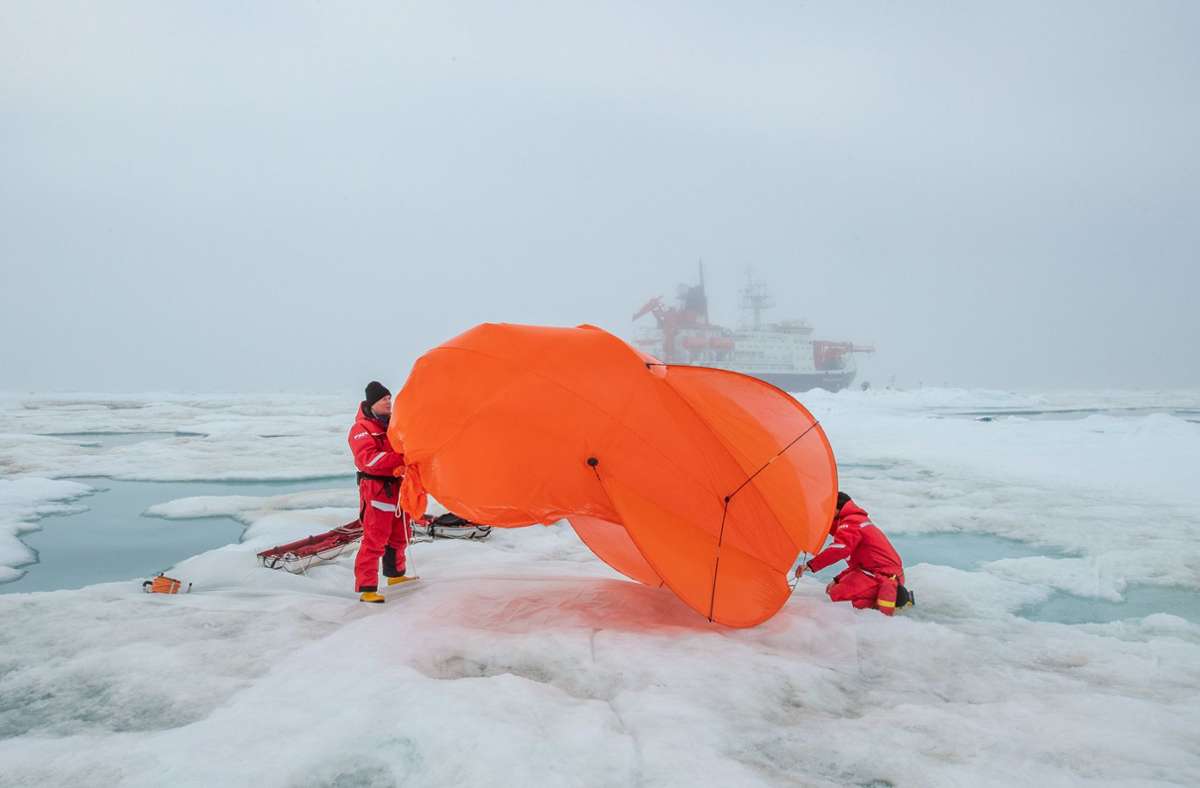 Mitarbeiter der Mosaic-Expedition packen einen Fesselballon zusammen. Seit Herbst 2019 schwebte dieser regelmäßig in mehreren hundert Metern über der Mosaic-Scholle, um Strahlung, Temperatur und Luftfeuchtigkeit in der unteren Atmosphäre zu messen.
