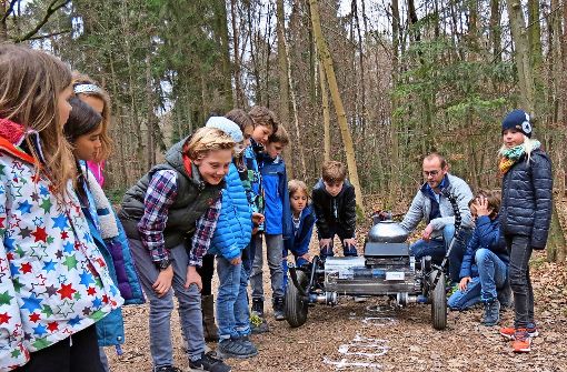 Schüler der Wilhelm-Hauff-Schule beobachten den niederländischen Künstler Gijs van Bon und seinen selbst gebauten Roboter bei der Arbeit. Foto: Julia Bosch