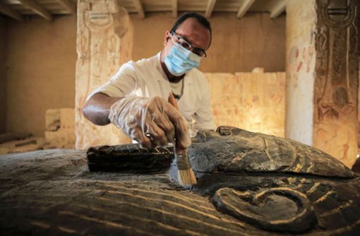 Ein ägyptischer Archäologe entfernt Staub aus einem der neu entdeckten Särge. Foto: dpa/Fadel Dawood