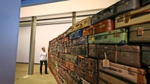 Die Galerieleiterin Isabelle Schenk-Weininger vor der Installation „Koffermauer / Klagemauer“ von Raffael Rheinsberg Foto: factum/Granville