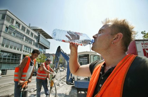 Ein Bauarbeiter löscht bei Hitze seinen Durst. Foto: Achim Zweygarth