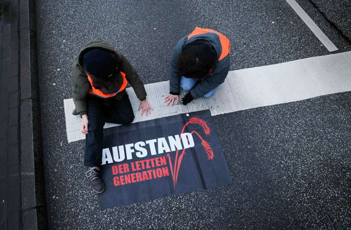 Aktivistinnen und Aktivisten der Letzten Generation kleben sich auf Autobahnen oder Zufahrten zu Flughäfen fest. Foto: dpa/Christian Charisius