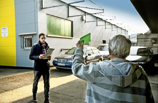 Marcel Schwenkedel (links) fungiert als Auto-Auktionator und nimmt die Gebote entgegen.  Allzu viele sind es nicht. Foto: Horst Rudel