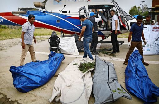 Ein Team der Nepal Army lädt die sterblichen Überreste von vier Bergsteigern aus einen Hubschrauber. Am Mount Everest sind binnen zwei Tagen vier Bergsteiger ums Leben gekommen. Foto: Skanda Gautam/ZUMA Wire/dpa