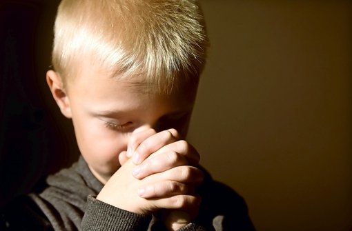 Ein kleiner Junge, versunken im stillen Gebet. Foto: Mizina/Fotolia72557242