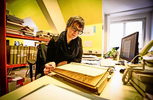 Gesa Grimme blättert in einem Inventarbuch des Lindenmuseums. Foto: Lichtgut/Leif Piechowski