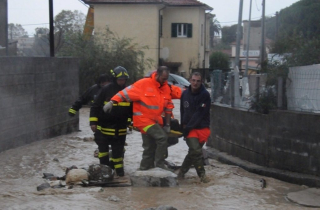 Helfer versuchen Einwohner in Carrara vor den Wassermassen in Sicherheit zu bringen.