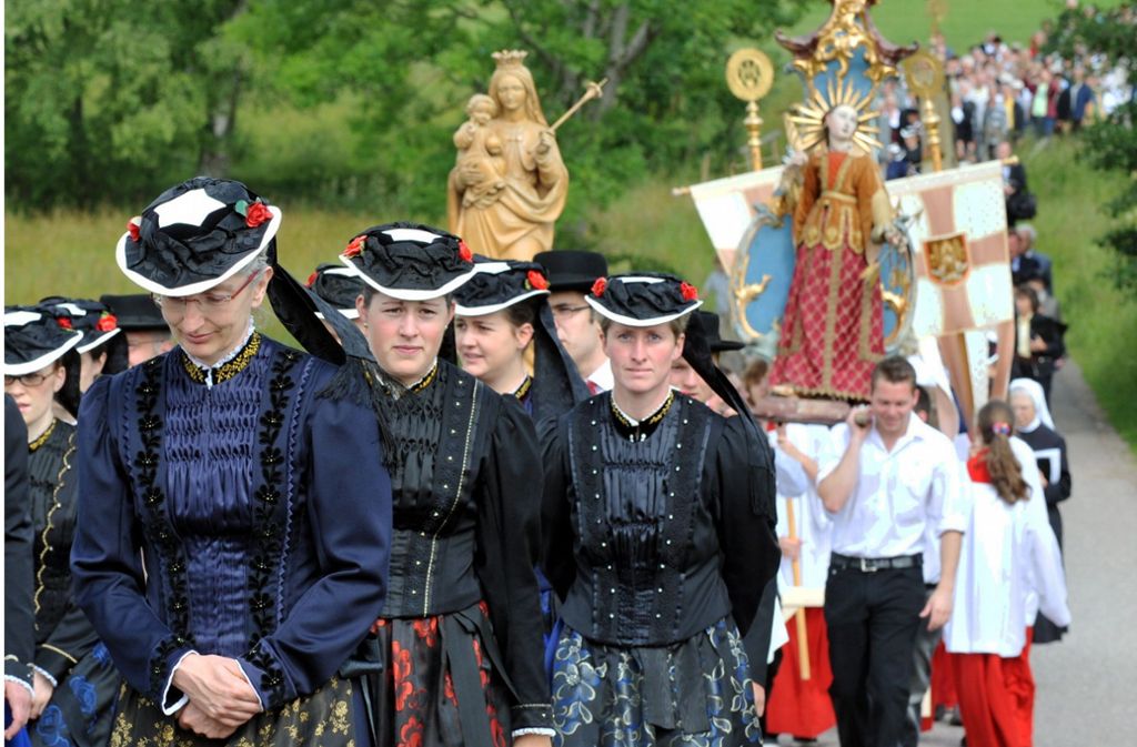 In der traditionellen Tracht von St. Peter im Schwarzwald begleiten katholische Gläubige die Fronleichnamsprozession. Nach einem Festgottesdienst ziehen sie unter Gebet und Gesang von Station zu Station um den Ort im Hochschwarzwald.