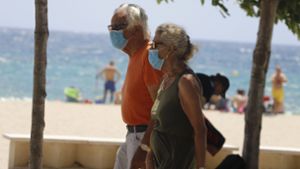 Maske am Strand  – trotzdem haben sich im Urlaub Tausende Reisende mit dem Coronavirus infiziert. Foto: dpa/Clara Margais