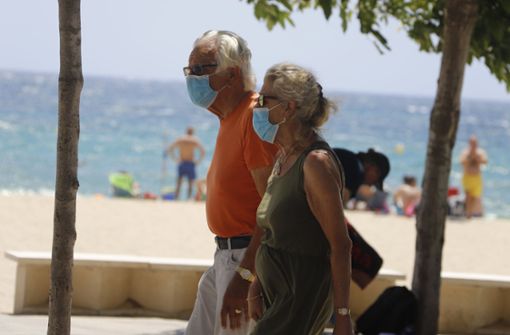 Maske am Strand  – trotzdem haben sich im Urlaub Tausende Reisende mit dem Coronavirus infiziert. Foto: dpa/Clara Margais