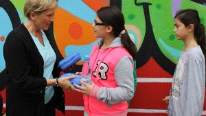 Schulbürgermeisterin Susanne Eisenmann übergibt den Schülern der Carl-Benz-Schule ihre neuen Frühstücksboxen. Foto:  