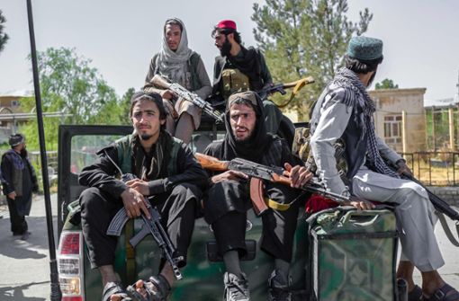 Taliban-Kämpfer posieren schwer bewaffnet auf Pick-ups. Einige von ihnen sind geschminkt. Foto: AFP/BULENT KILIC