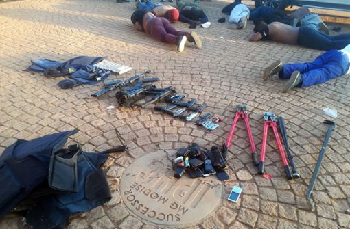 Einige Tatverdächtige liegen nach dem Polizeieinsatz auf dem Boden. Foto: dpa