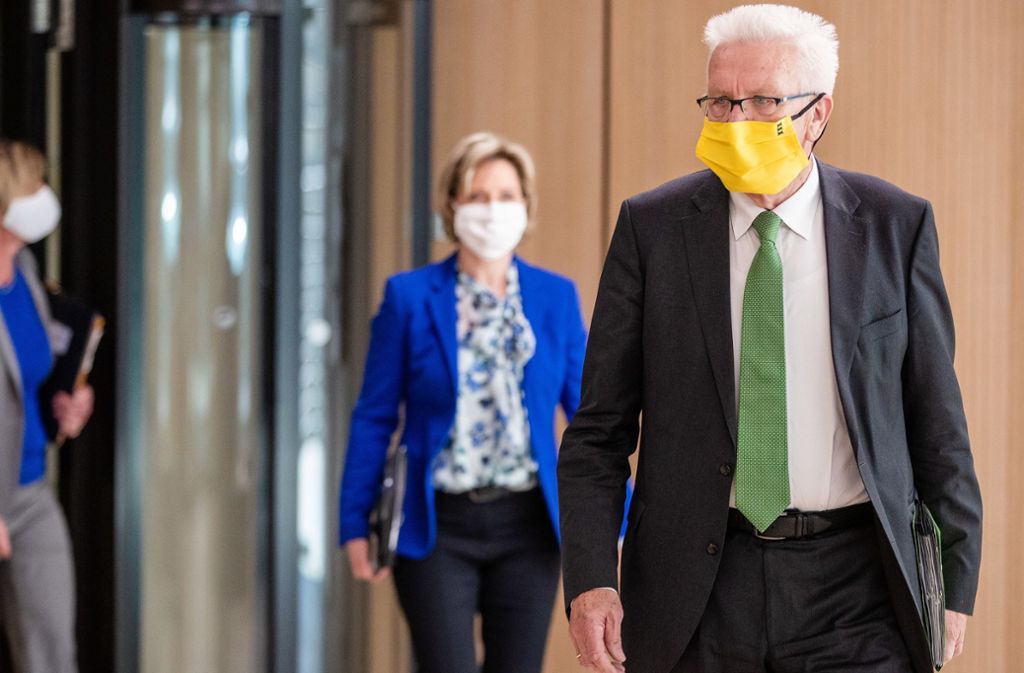 Ministerpräsident Winfried Kretschmann mit einer Maske in den Landesfarben schwarz und gelb. Foto: dpa/Christoph Schmidt