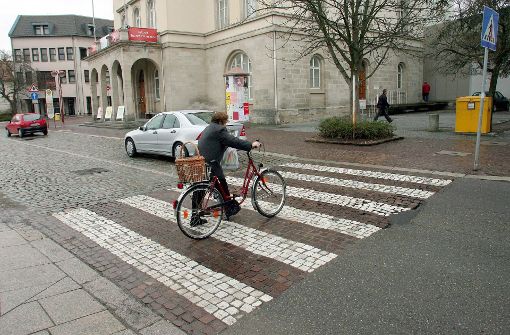 Eine Frau schiebt ihr Fahrrad in Sindelfingen über einen Zebrastreifen aus italienischem Carrara-Marmor. Lange galten solche Beläge  als Beleg für den Reichtum baden-württembergischer Städte. Foto: dpa