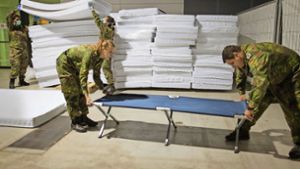 Soldaten der Bundeswehr bauen im Oktober 2015 in einer Stuttgarter Messehalle Betten für Flüchtlinge auf. Material, das damals knapp war, ist inzwischen teils im Überfluss vorhanden. Foto: dpa