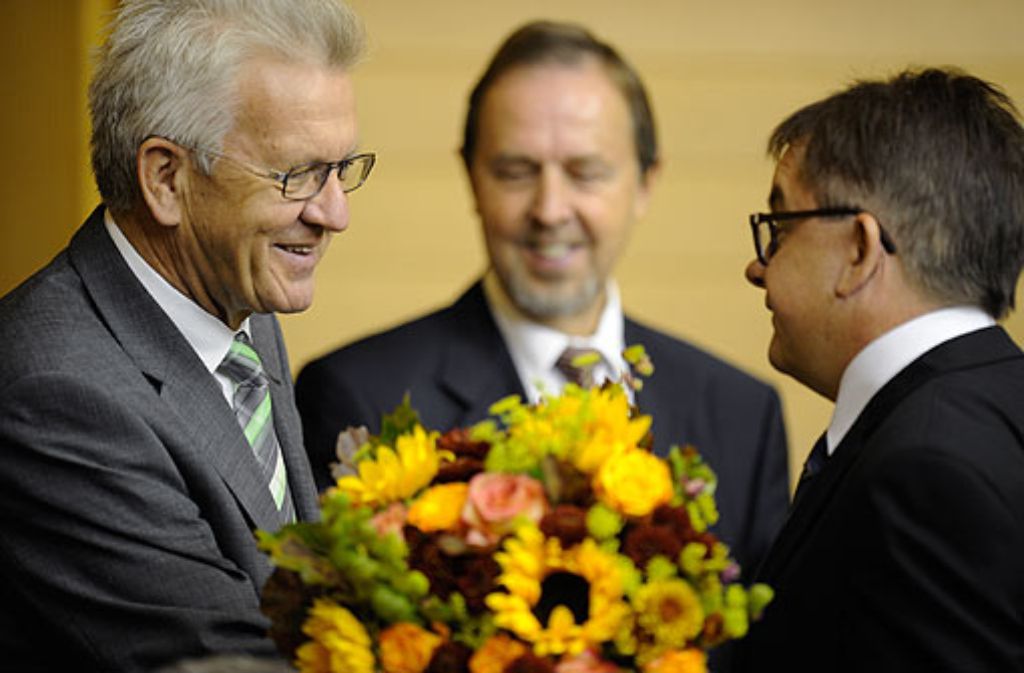 Ministerpräsident Winfried Kretschmann (links) gratuliert dem neuen Landtagspräsidenten Guido Wolf zur Wahl. Im Hintergrund: Der CDU-Abgeordnete Karl Zimmermann. Foto: dapd