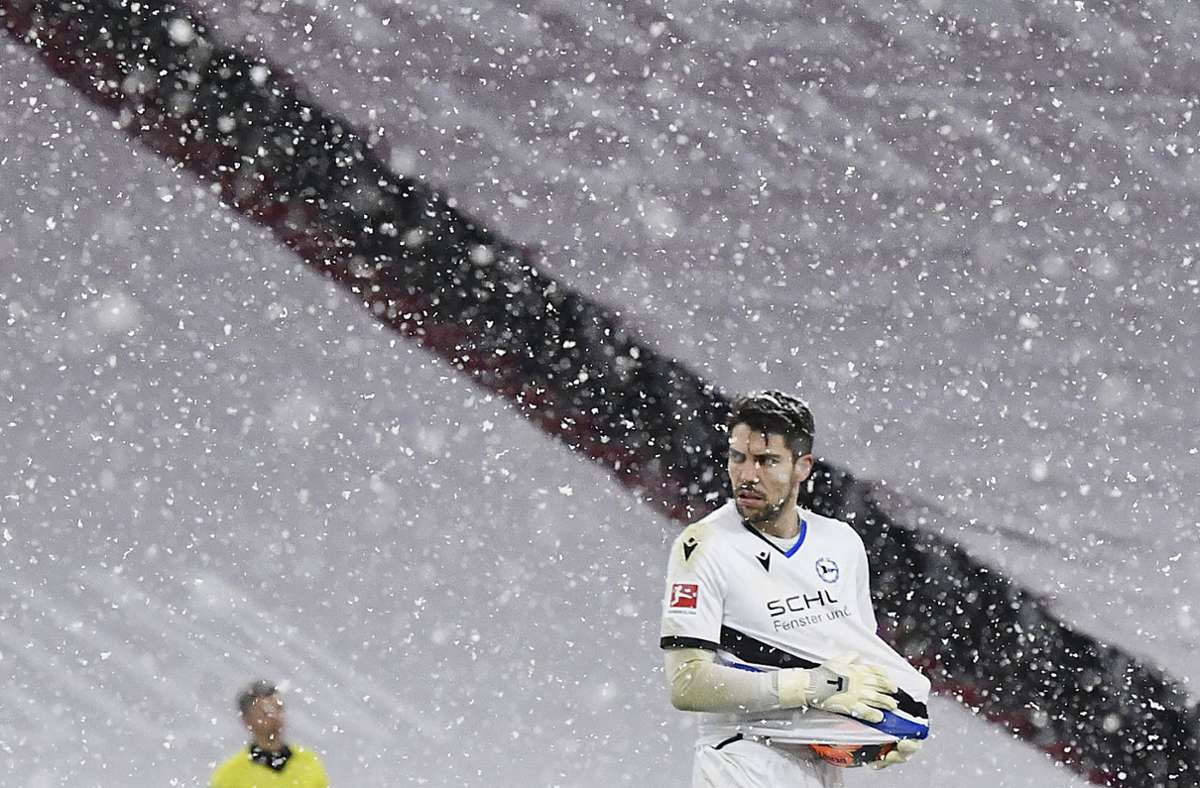 Bielefelds Torwart Stefan Ortega säubert im Scheefall den glitschigen Ball.