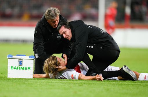 Borna Sosa vom VfB Stuttgart wird von den Mannschaftsärzten behandelt. Foto: dpa/Tom Weller