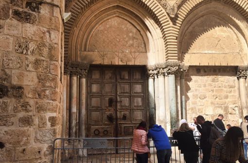Touristen stehen vor der verschlossenen Grabeskirche in Jerusalem. Foto: dpa