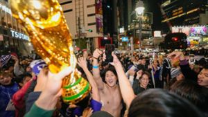 In Tokio feiern Menschen ohne Maske den Sieg der japanischen Elf gegen Deutschland. In China reibt man sich ob solcher Bilder die Augen. Foto: dpa/Kyodo News