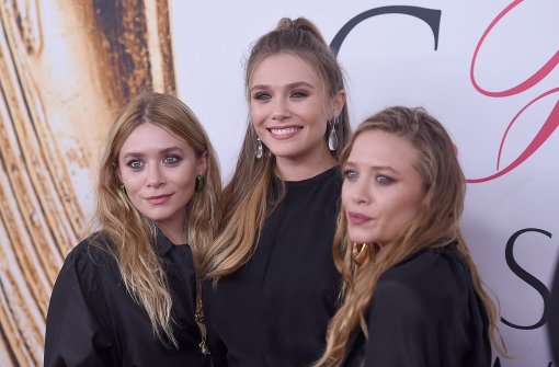 Die Olsen-Zwillinge Mary-Kate (links) und Ashley (rechts) sind seit ihrer Kindheit echte Hollywood-Stars. Bei den CFDA Fashion Awards traten sie zusammen mit ihrer Schwester Elizabeth (Mitte) auf. Foto: Getty