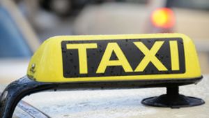 Betrunkener klammert sich auf Motorhaube von Taxi fest