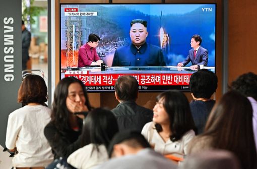 Menschen schauen im  Bahnhof in Seoul auf einen Bildschirm, auf dem eine Nachrichtensendung mit Filmmaterial von Nordkoreas Führer Kim Jong Un zu sehen ist. Foto: AFP/Jung Yeon-Je