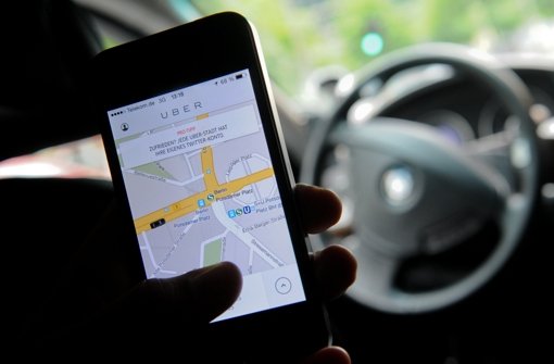 Ein Fahrgast benutzt in Berlin die Handy-App von Uber. Das umstrittene Unternehmen hat jetzt angekündigt, in Stuttgart nicht aktiv werden zu wollen Foto: dpa