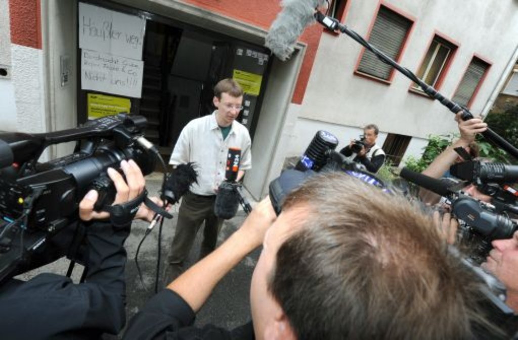 Parkschützer-Sprecher Matthias von Herrmann spricht vor dem Büro der Stuttgart21-Gegner in der Urbanstraße mit Journalisten. Das Parkschützer-Büro wurde am Morgen von der Polizei durchsucht. Foto: dpa