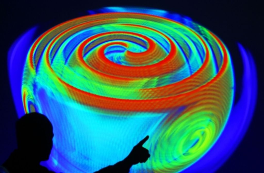 Ein Mitarbeiter des Max-Planck-Instituts für Gravitationsphysik in Potsdam erläutert anhand einer Projektion einer Computersimulation die Ausbreitung von Gravitationswellen. Foto: dpa