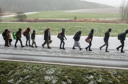 Flüchtlinge gehen Ende November 2015 an der deutsch-österreichischen Grenze nahe Wegscheid (Bayern) während eines Schneeschauers nach Deutschland. Foto: dpa