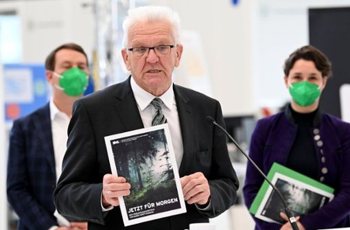 Winfried Kretschmann mit dem  Koalitionsvertrag der grün-schwarzen Landesregierung  (Archivbild) Foto: dpa/Bernd Weißbrod