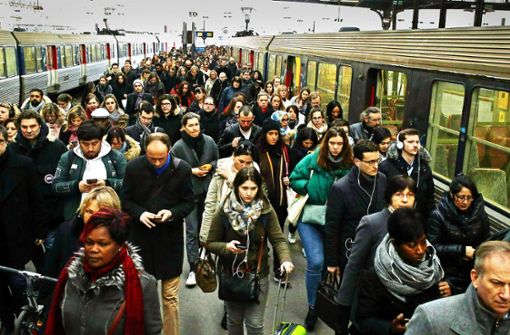 Pendler gehen über einen Bahnsteig des Bahnhofs Saint Lazare in Paris. Wegen des Streiks kam es zu vielen Zugausfällen. Foto: AP