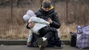 Eine geflüchtete Ukrainerin wartet in Rumänien mit ihrem Kind auf die Weiterfahrt. Foto: dpa/Andreea Alexandru