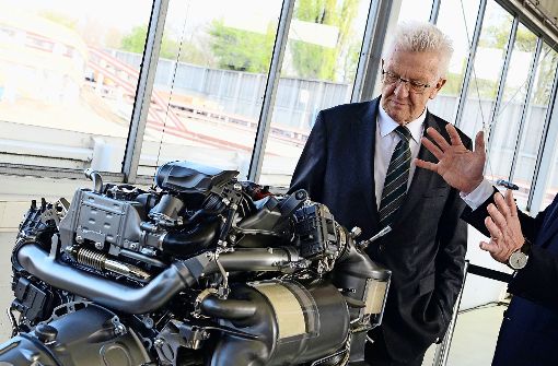 Ministerpräsident Winfried Kretschmann mit einem Dieselmotor bei einer Daimler-Werksbesichtigung. Foto: dpa