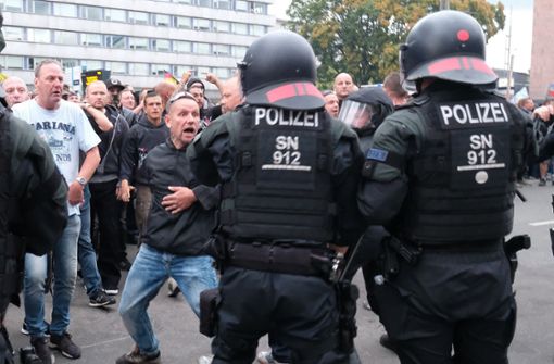 Polizisten versuchen, die demonstrierenden Rechtsextremen am Montagabend   in Chemnitz in Schach zu halten. Foto: dpa